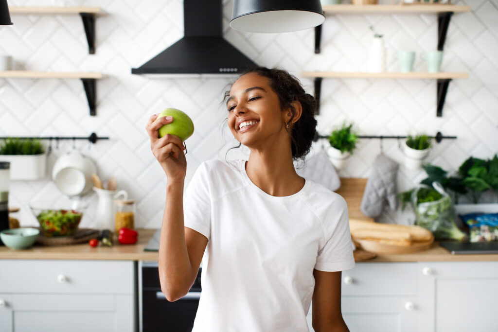 The hidden Link Between Blood Sugar and Your Mood smiled attractive mulatto girl is preparing to bite an apple and